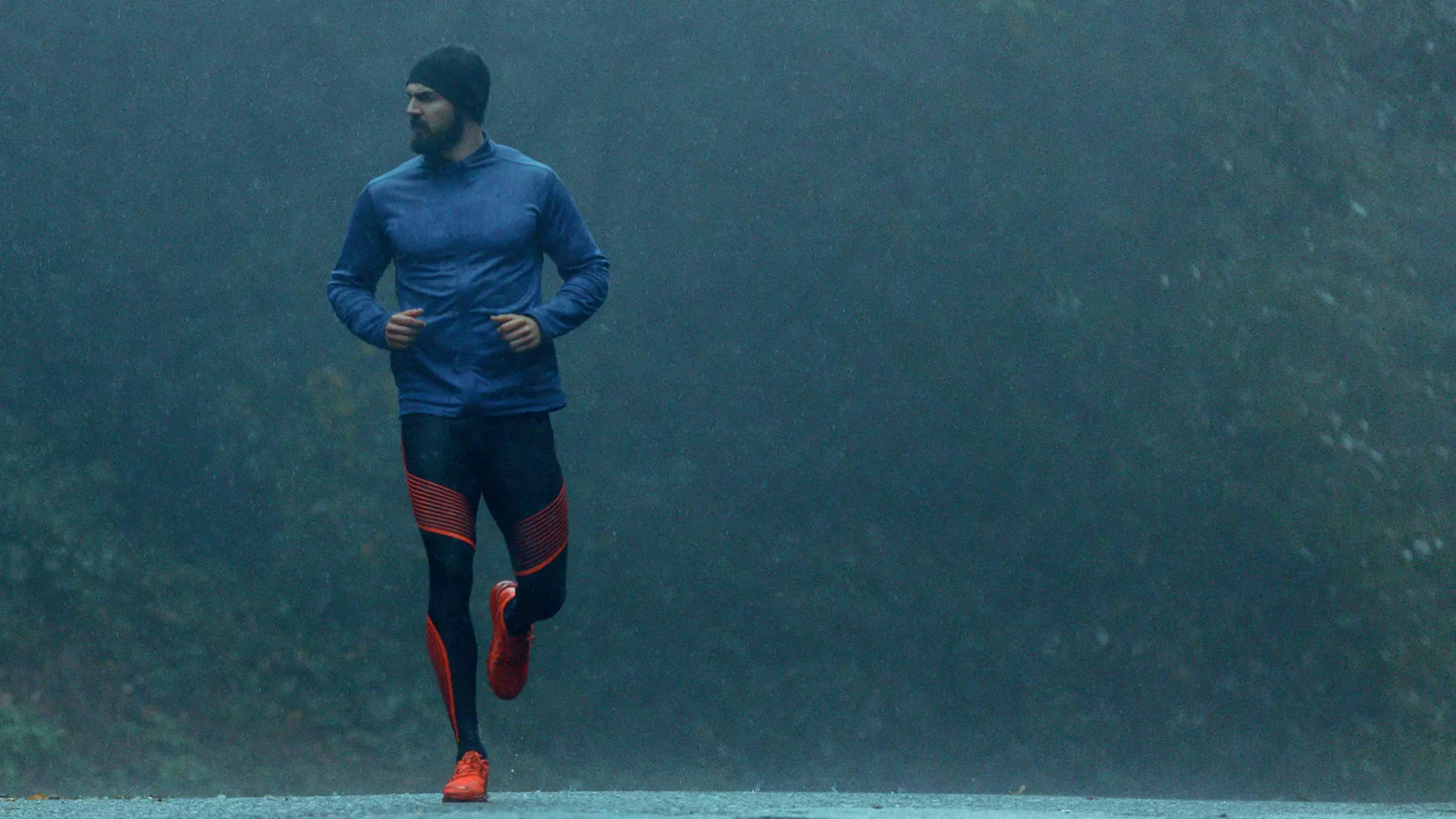Sportlicher Mann joggt im strömenden Regen