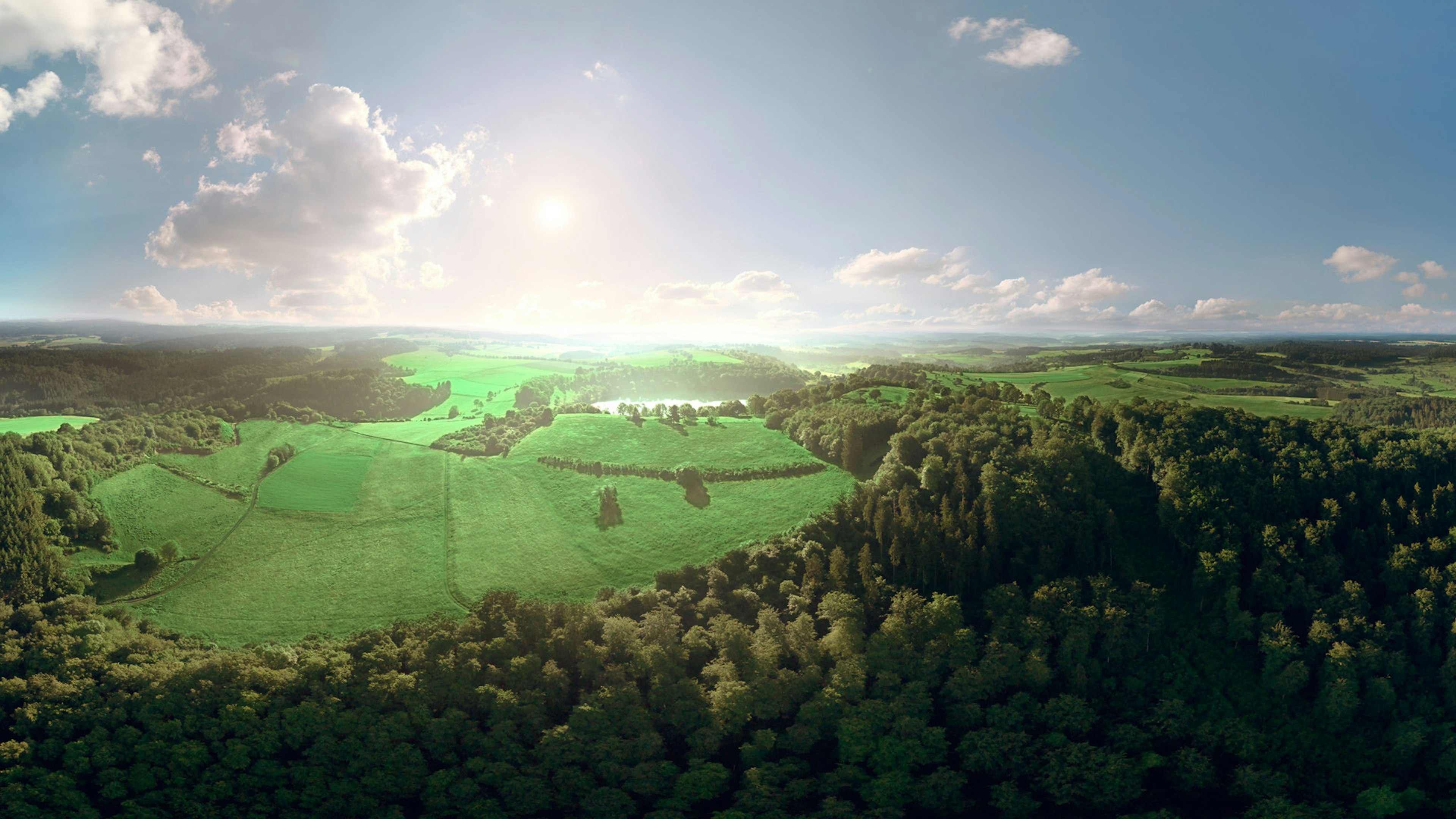Eifel landscape with green fields, forests and a  maar. 